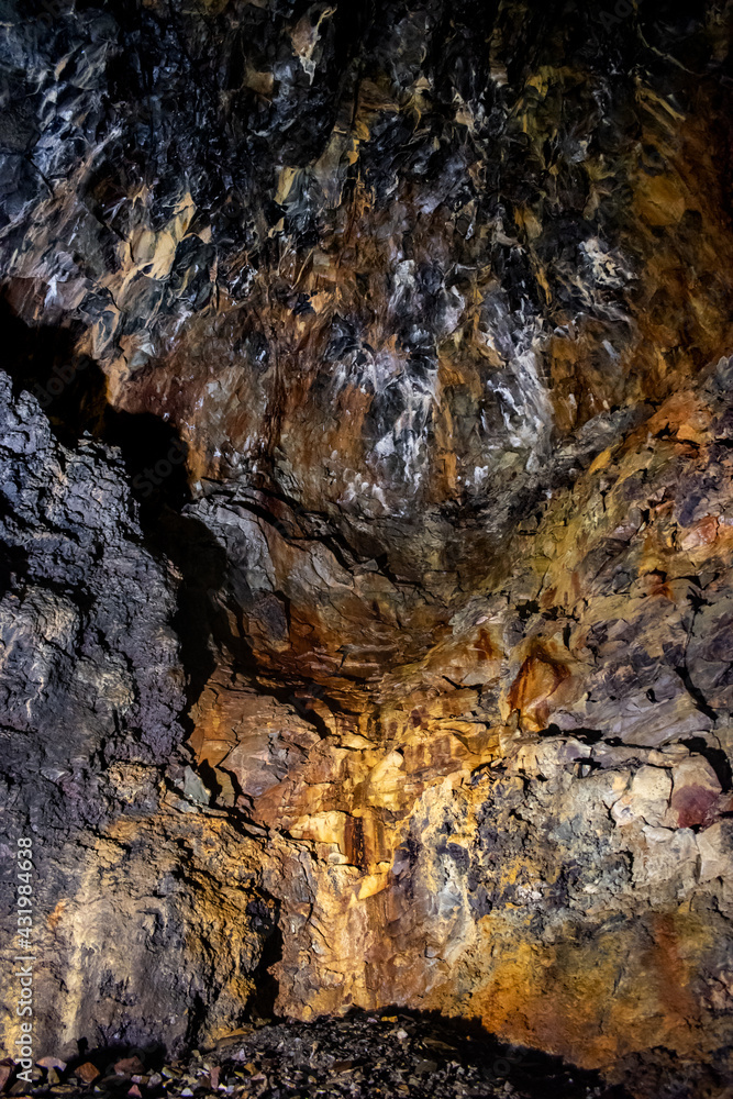 Texture of colored wall in cavity with black and obsidian rock in Algar do Carvão, Terceira - Azores PORTUGAL