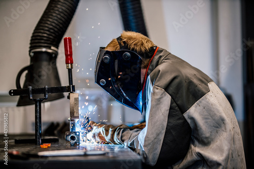 Welder with coveralls working at factory photo