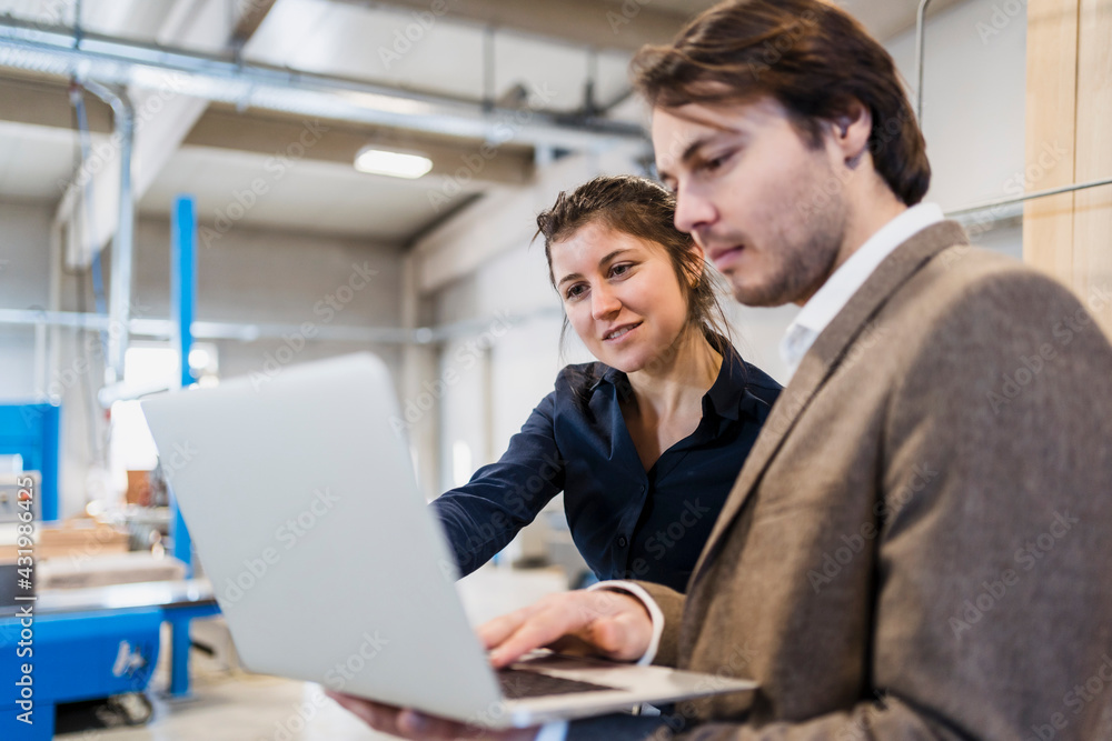 Business people using laptop while working at industry Business people using laptop while working at industry