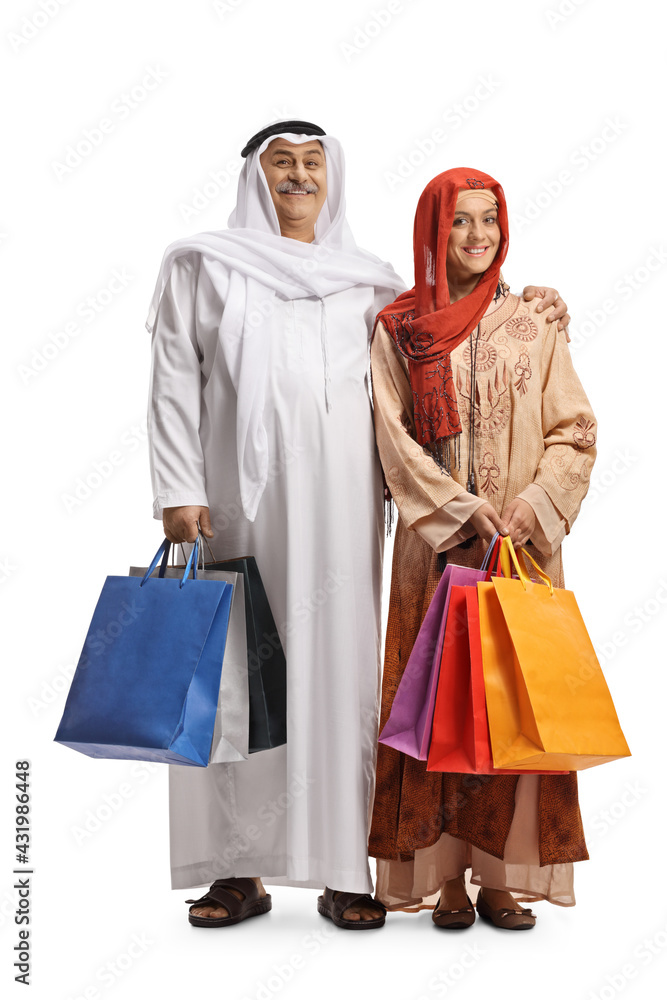 Full length portrait of a mature arab man and a young muslim woman holding shopping bags Full length portrait of a mature arab man and a young muslim woman holding shopping bags
