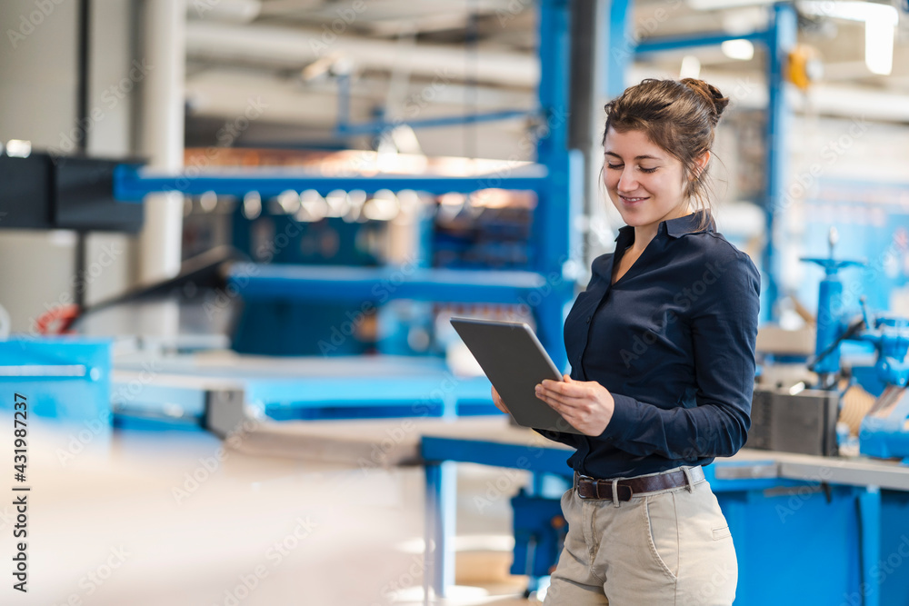 Businesswoman using digital tablet while standing at industry Businesswoman using digital tablet while standing at industry