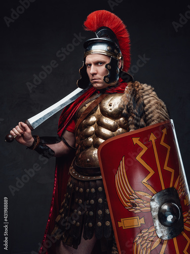 Roman soldier weared in bronze armor holding sword