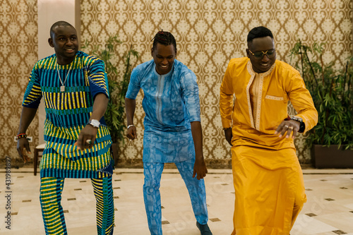 Smiling friends dancing while standing in banquet photo