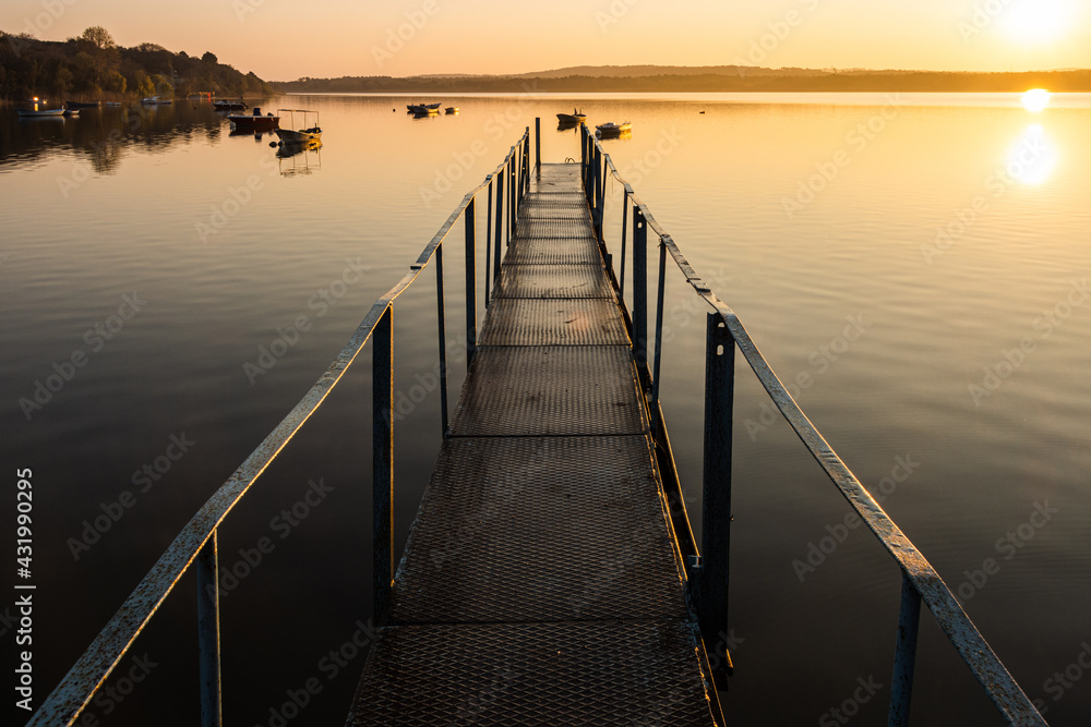 View of the iron pier and sunrise over the lake. Calm and peaceful scene. Long exposure landscape nature photography