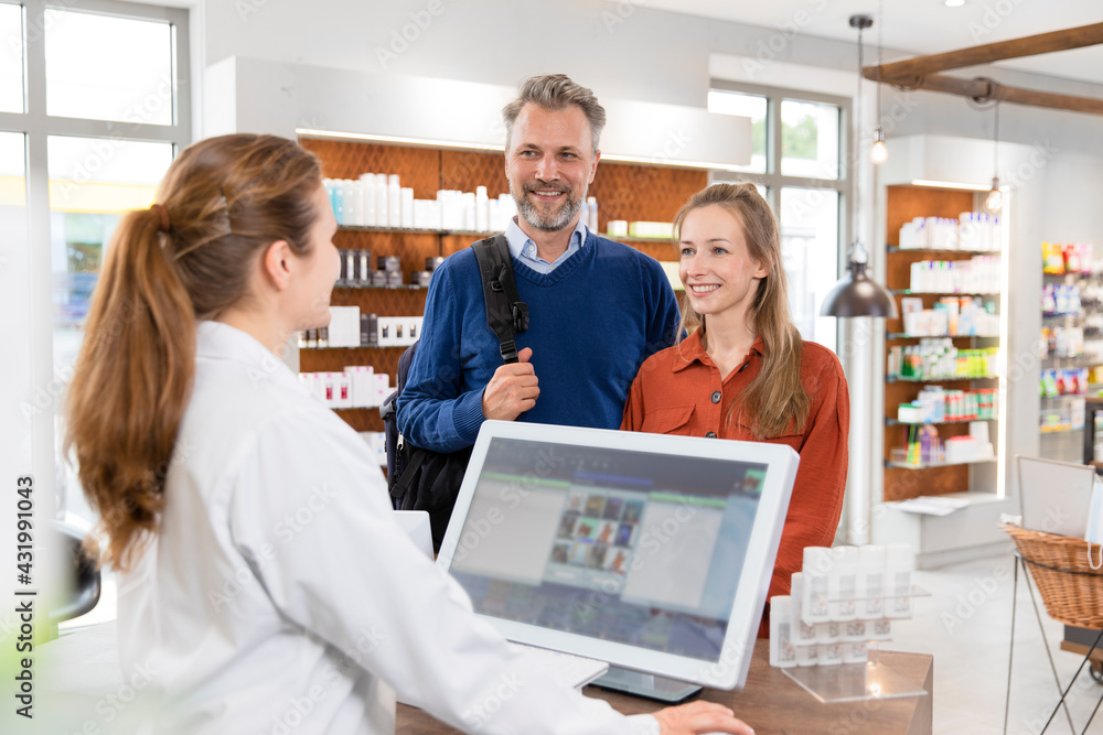 Couple talking with female pharmacist at pharmacy checkout Couple talking with female pharmacist at pharmacy checkout