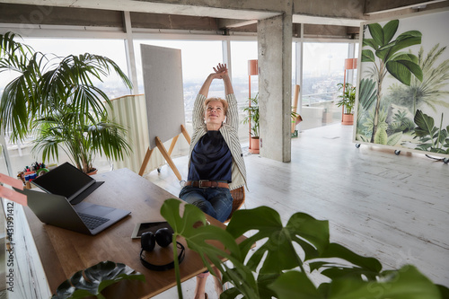 Female entrepreneur relaxing while sitting at desk in office