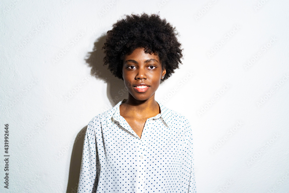 Curly hair woman staring while standing against white background Curly hair woman staring while standing against white background