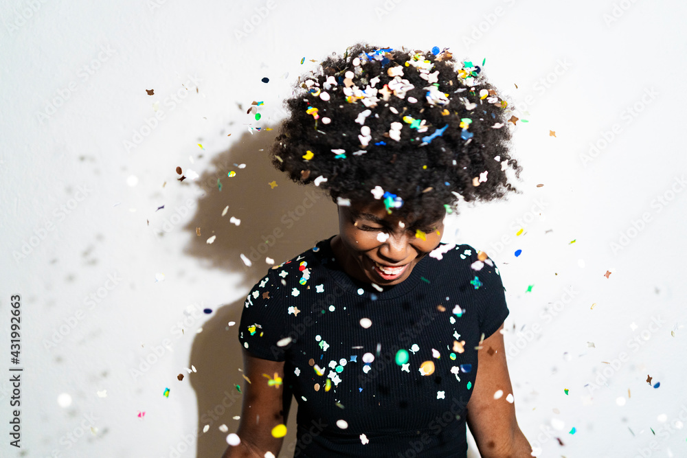 © Giorgio Fochesato/Westend61 - Smiling woman with confetti falling on head standing against white background © Giorgio Fochesato/Westend61 - Smiling woman with confetti falling on head standing against white background