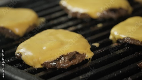 Meat burger cutlet with melted cheese on the grill grate. Cooking a meat cutlet for burger on grill.