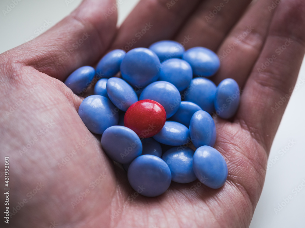 Top view of blue and red chocolate candy in a hand with copy space Top view of blue and red chocolate candy in a hand with copy space