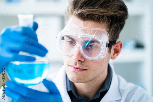 Handsome male scientist examining chemical in laboratory photo