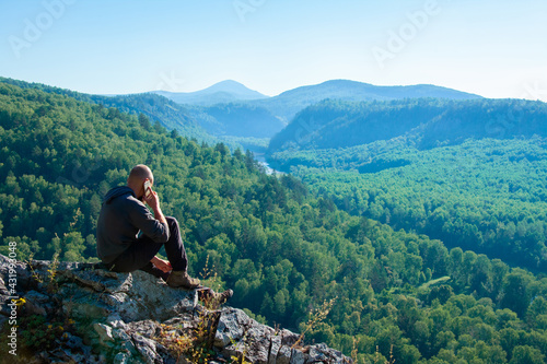 Man talking on a mobile phone on a mountain landscape background © Stanislaw Mikulski