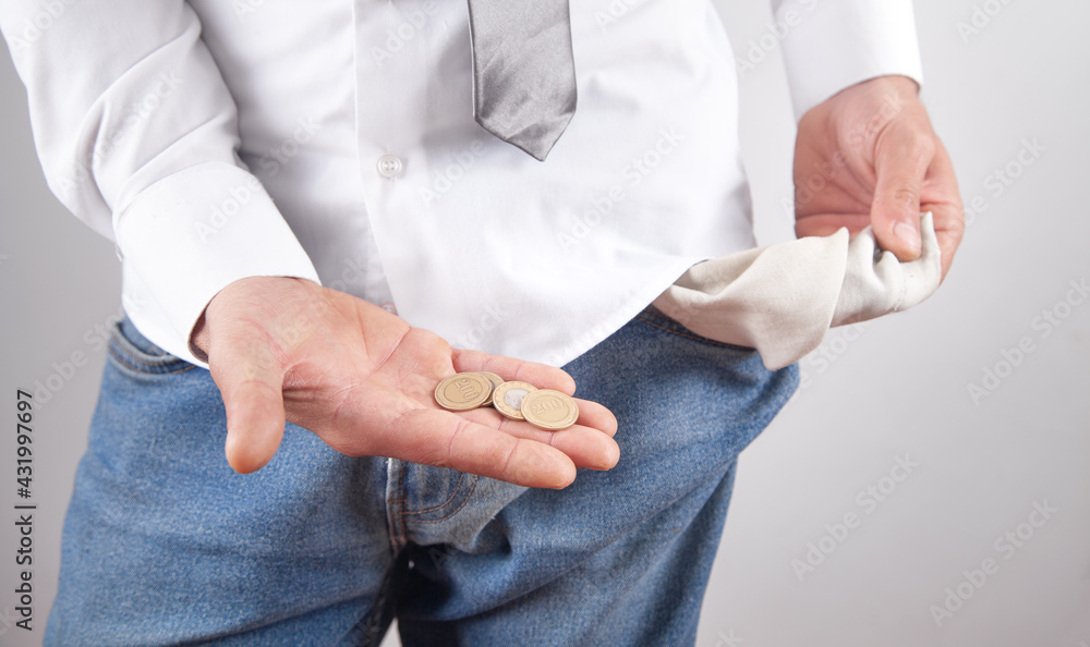 Man with a empty pocket showing coins.