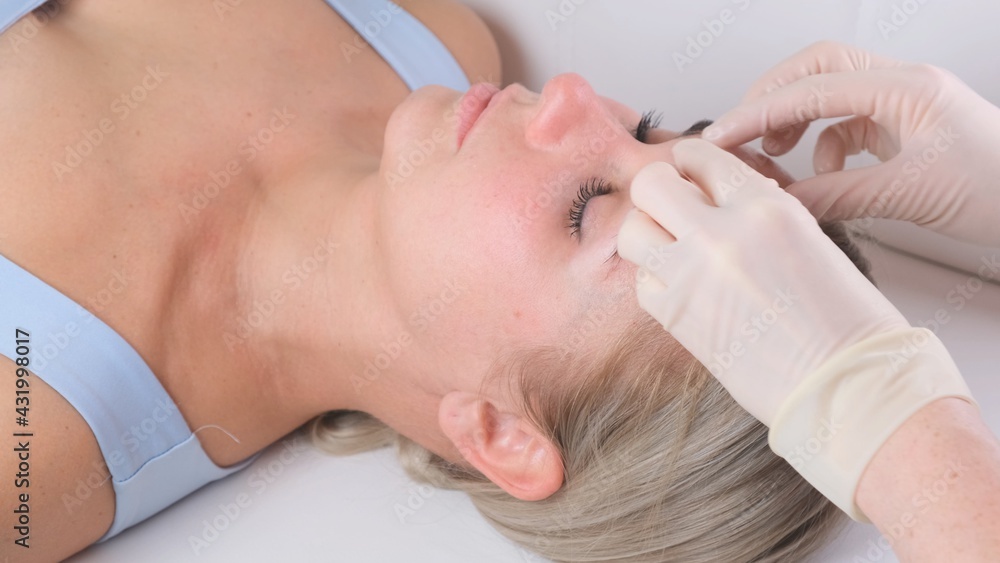 Beautiful woman in salon having facial massage.