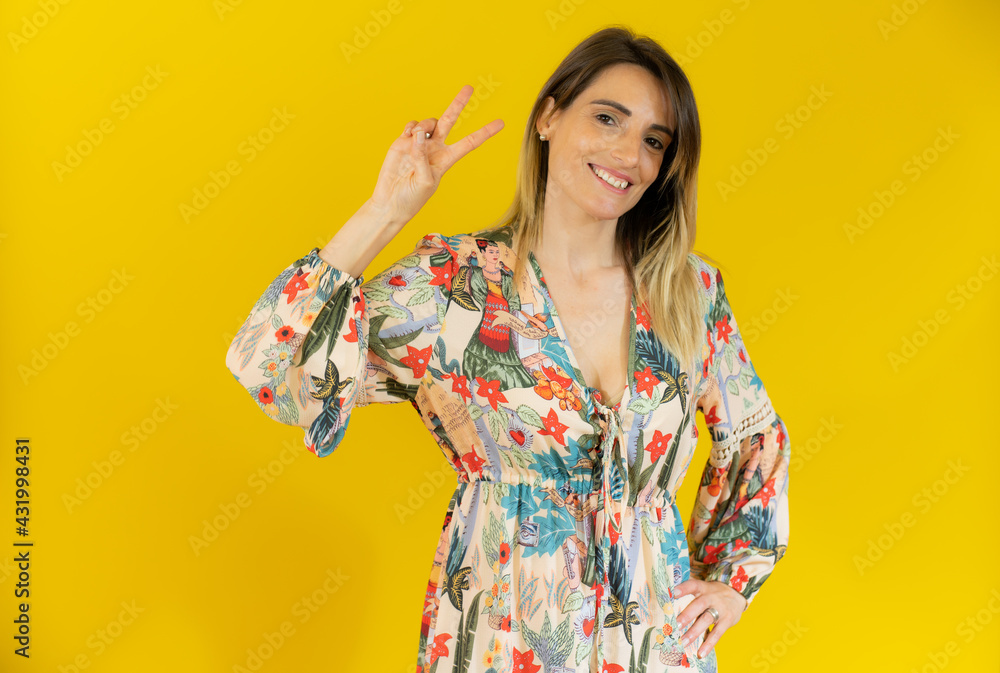 Young caucasian woman isolated on yellow background smiling and showing victory sign Young caucasian woman isolated on yellow background smiling and showing victory sign