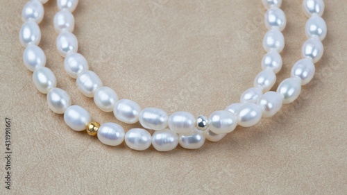 Luxury elegant baroque pearl bracelets on beige textured leather background