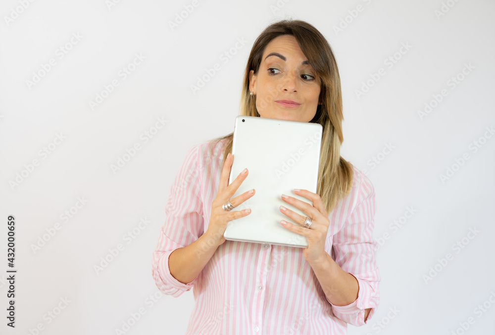 Image of woman in striped shirt standing isolated over white background using a tablet. Image of woman in striped shirt standing isolated over white background using a tablet.