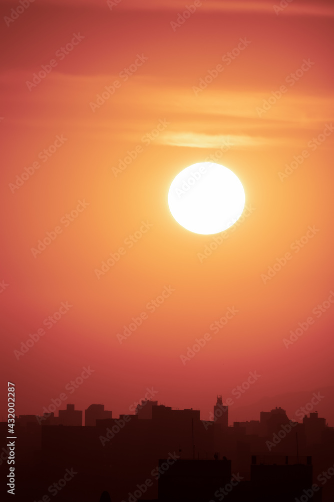 Obraz premium Por do Sol na cidade de São Paulo. Sol grande, fotografado em close up. Silhueta dos prédios da cidade. Espaço para texto.