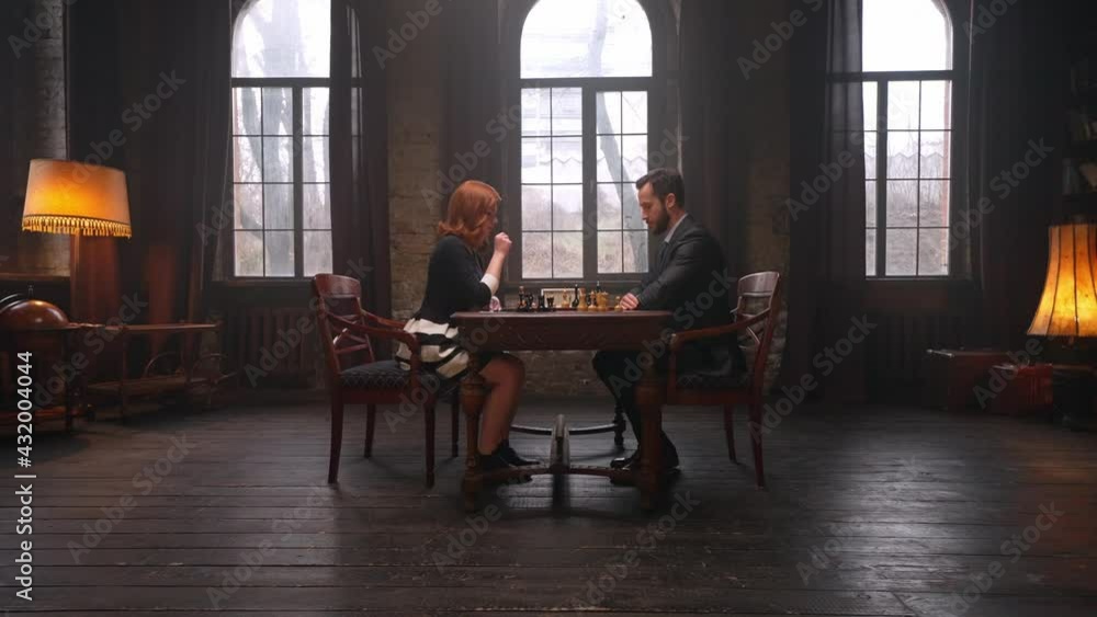 Two chess players man and woman play chess. Debut Accepted Queen's Gambit, King's Gambit, Philidor's Defense. Cinematic filming of a chess game. Antique chess board. This shot can be used for films Two chess players man and woman play chess. Debut Accepted Queen's Gambit, King's Gambit, Philidor's Defense. Cinematic filming of a chess game. Antique chess board. This shot can be used for films