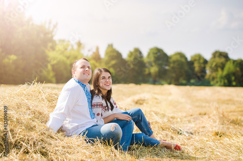 Young couple in the hay in Ukrainian shirts
