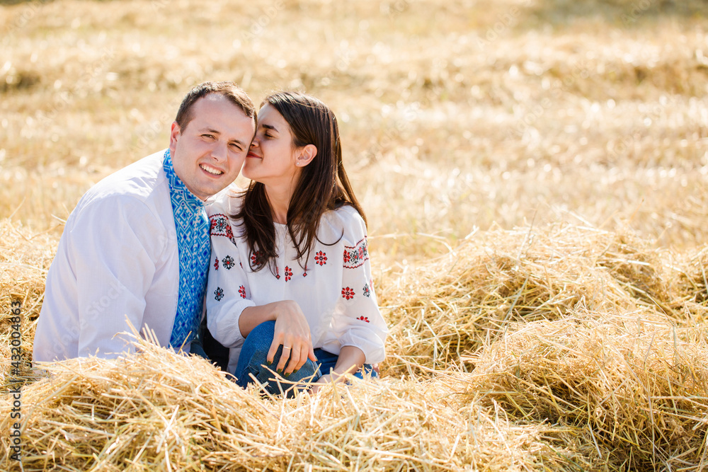Girl kisses a guy sitting on a haystack Girl kisses a guy sitting on a haystack