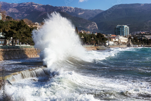 Murais de parede A huge white wave with spray on the Yalta embankment