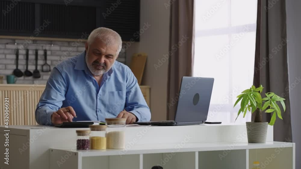 grey haired man is working at home office, calculating and making report, financial director or auditor grey haired man is working at home office, calculating and making report, financial director or auditor