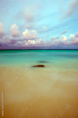 Ocean waves are blurred as they come in an out over rocks on the beach of Playa del Carmen Mexico. photo