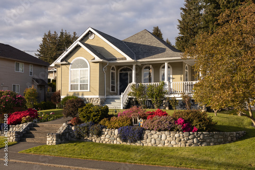 Comfortable suburban home in nice neighbourhood in the spring with flowering shrubs in front
