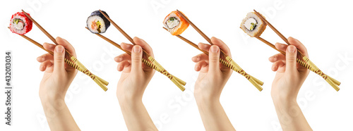 Women's hands hold sushi rolls with sticks. White background. Creative concept. Clipping path.