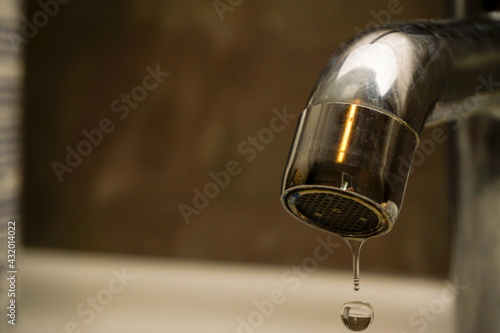 Water shortage drop of water on the faucet close up view