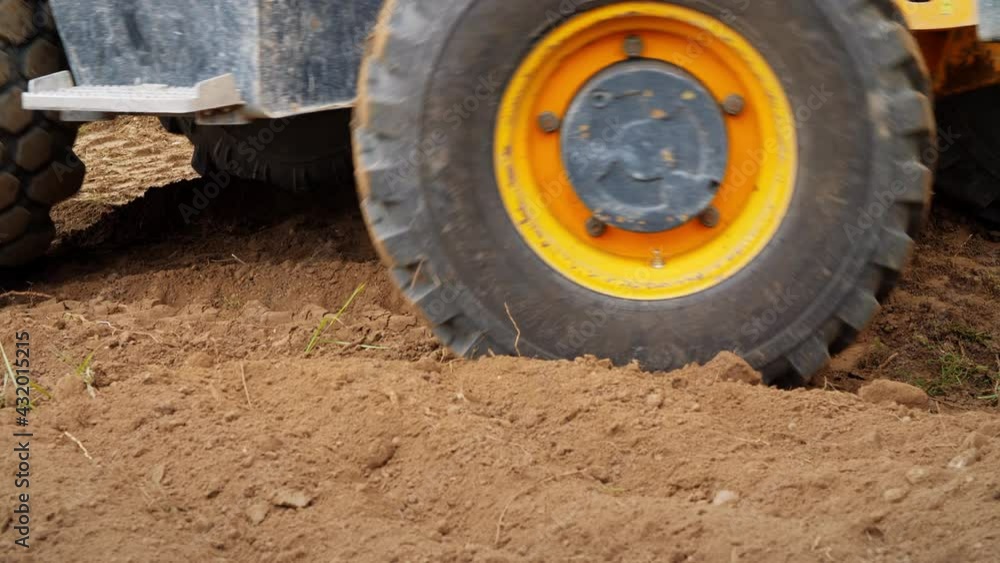 Excavator working. Backhoe operating in a Land. Wheels close up Excavator working. Backhoe operating in a Land. Wheels close up