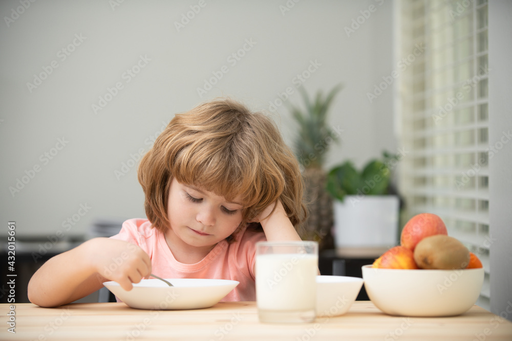 Child dinner. Portrait of fun kid having healthy tasty snack. Small kid crazy posing by kitchen table. Child dinner. Portrait of fun kid having healthy tasty snack. Small kid crazy posing by kitchen table.