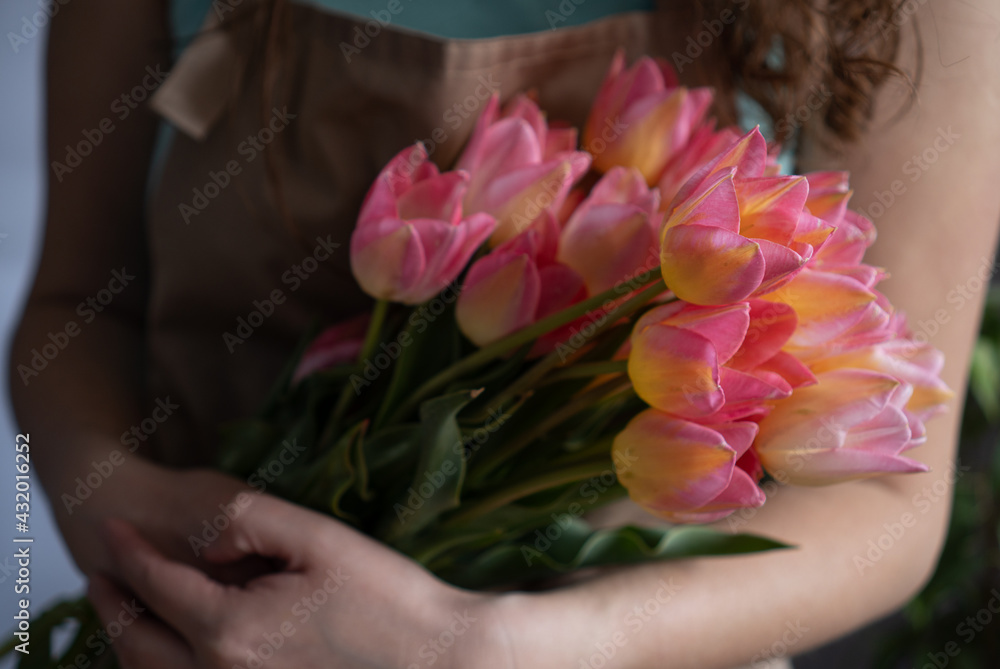 Close-up of a bouquet of tulips in the hands of a woman Close-up of a bouquet of tulips in the hands of a woman
