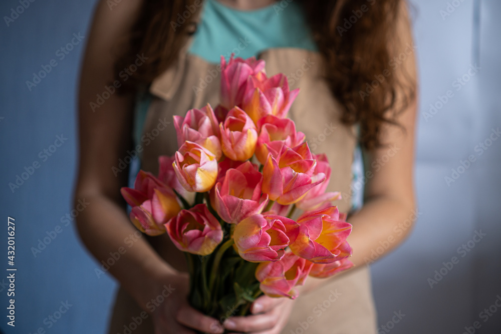 Close-up of a bouquet of tulips in the hands of a woman