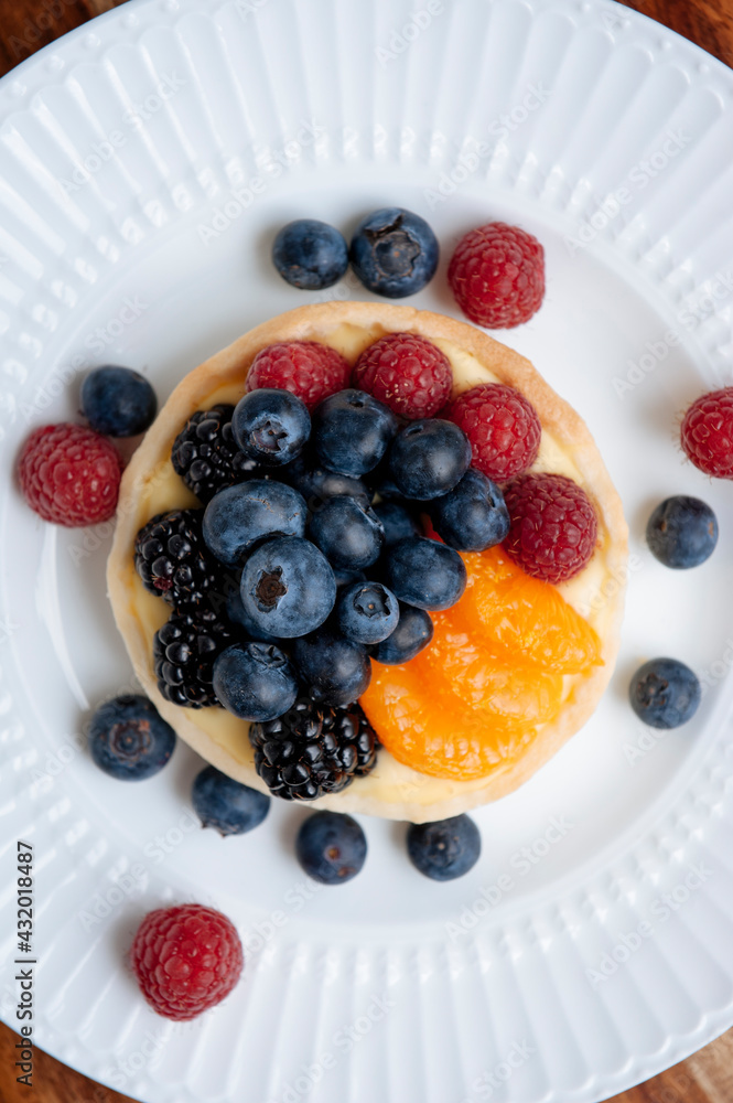 Mixed fruit tart including blueberries and raspberries with mandarins on a custard filling Mixed fruit tart including blueberries and raspberries with mandarins on a custard filling
