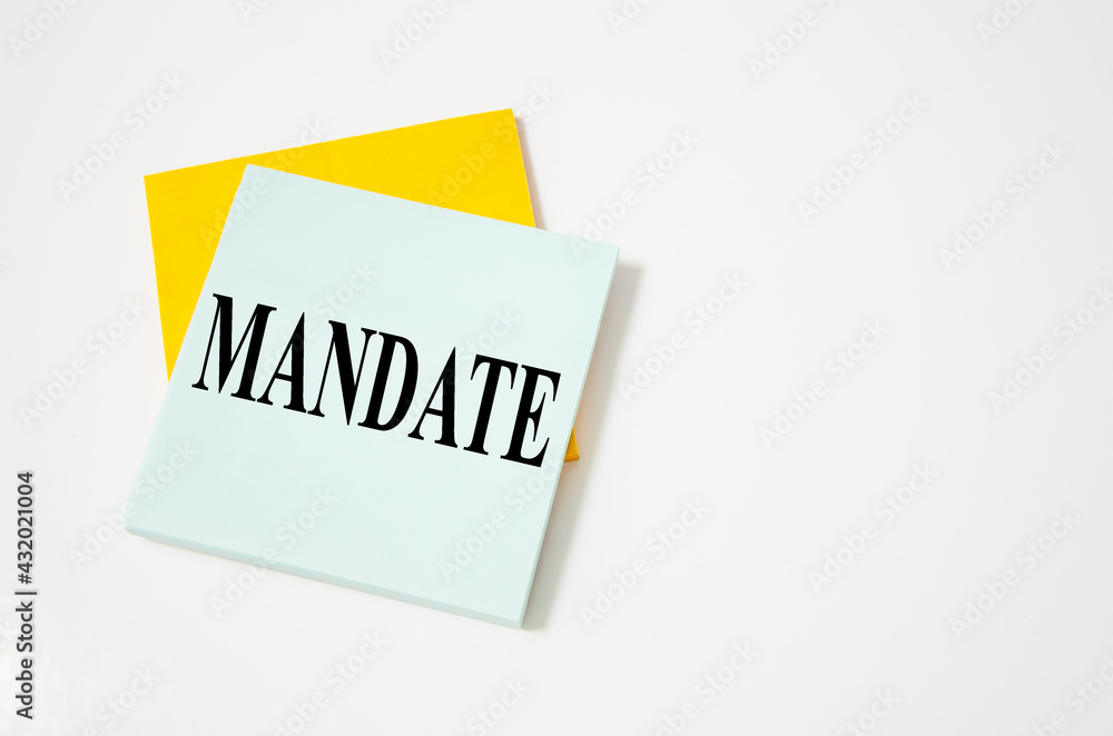 mandate text written on a white notepad with colored pencils and a yellow background. word mandate text written on a white notepad with colored pencils and a yellow background. word