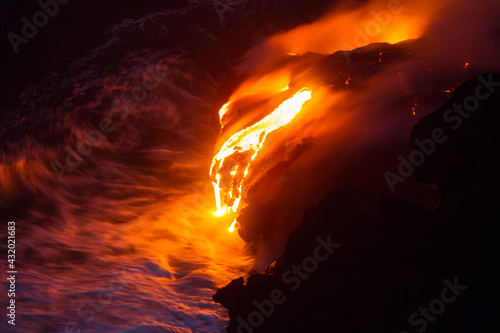 Lava from the Kilauea Volcano on the big island of Hawaii pours over cliffs into the Pacific Ocean. photo