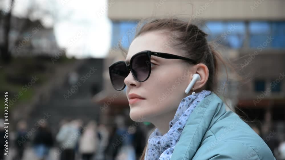 Hipster caucasian girl portrait in sunglasses having fun and listens to music in the headphones Hipster caucasian girl portrait in sunglasses having fun and listens to music in the headphones