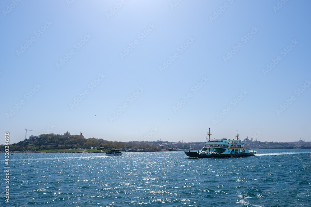 a ferry boat with cars and vehicles moving on Marmara Sea and sun shines in a clear air with copy space transportation concept
