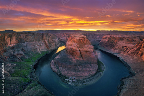 Epic sunset light gives a warm glow to the canyon walls around lake Powell at Horseshow Bend.