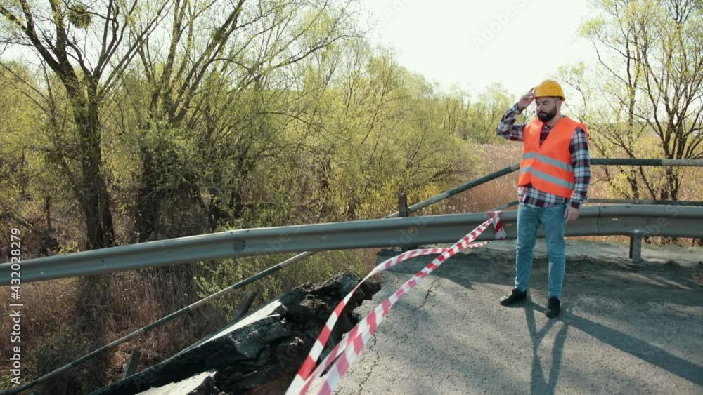 View of the destroyed road bridge as consequences a natural disaster. Large bridge. Destruction of canvas, collapse of the bridge structure. Engineer in hardhat audit natural disaster View of the destroyed road bridge as consequences a natural disaster. Large bridge. Destruction of canvas, collapse of the bridge structure. Engineer in hardhat audit natural disaster