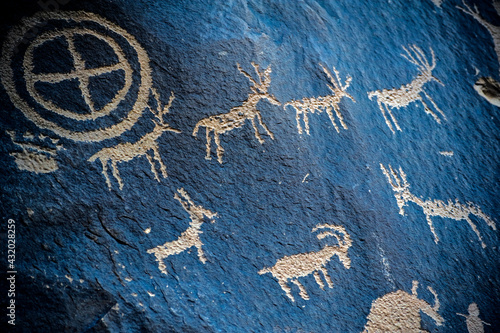 Petroglyphs pecked through black desert varnish in Indian Creek Utah. photo