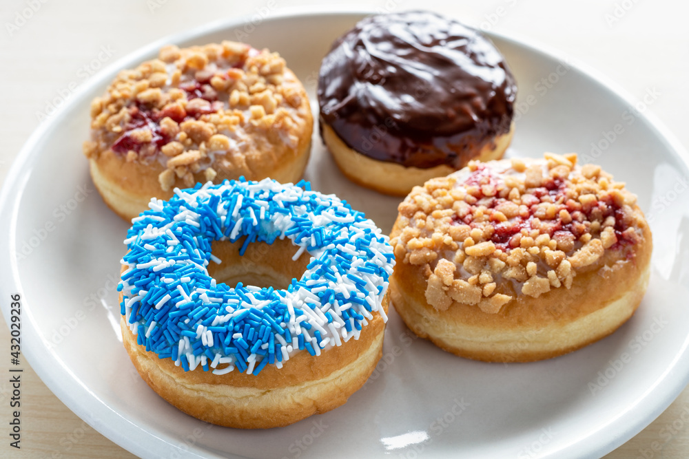Four different donuts on white plate.
