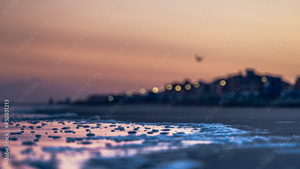 Obraz premium Paisaje atardecer de mar con ciudad de fondo