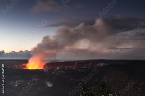 The glow of magma within the crater of Kiluaea lights up the rising smoke as the first hints of dawn begin to light up the night sky. photo