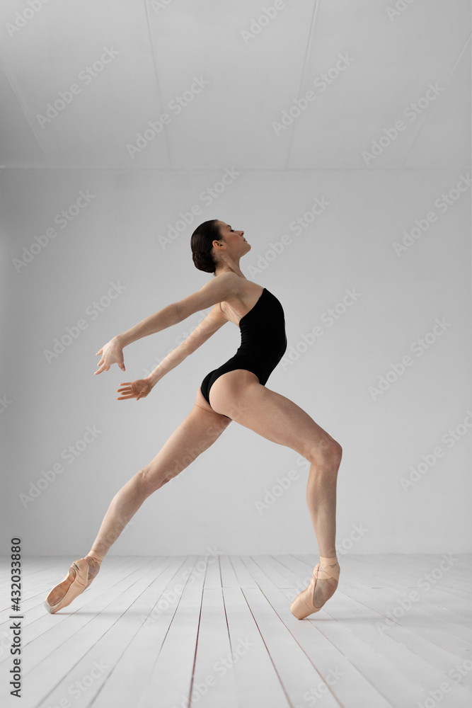 Obraz premium Young beautiful skinny ballerina is posing in studio