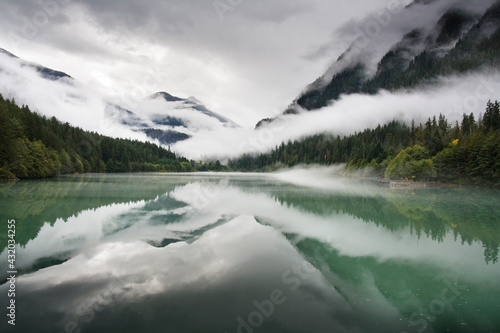 Mist slowly lifts from the forests and mountains surrounding Diablo Lake, an artificial reservoir formed by Diablo Dam in the heart of North Cascades National Park, Washington. photo