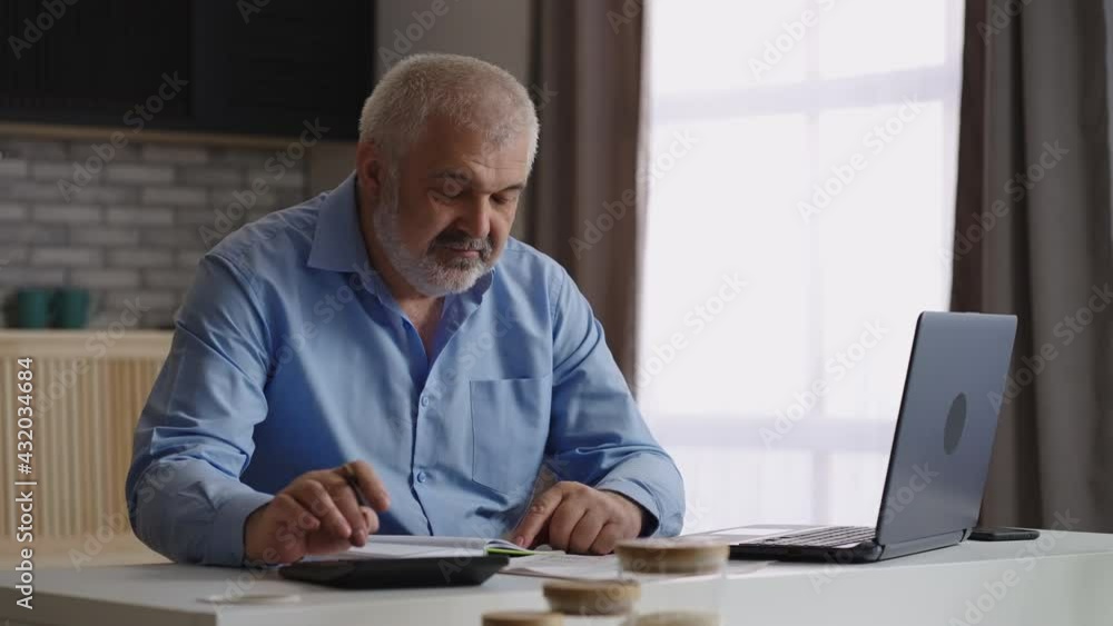 aged man is filling in report in laptop, financial specialist or accountant is working at home office aged man is filling in report in laptop, financial specialist or accountant is working at home office