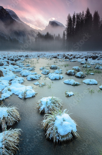 Fresh snow and frozen puddles point the way to Half Dome in Yosemite National Park, CA photo